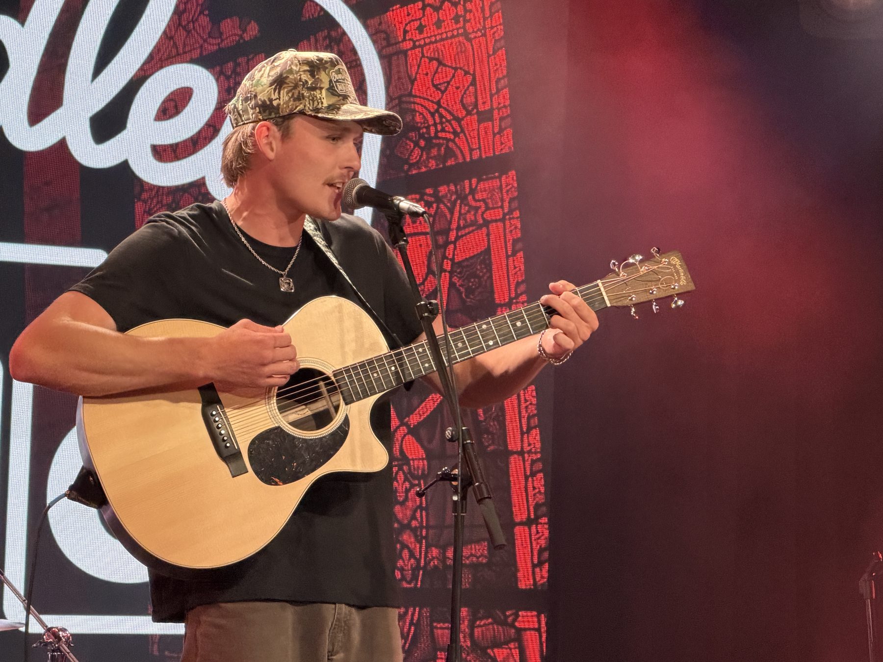 Owen Waidley singing with his guitar on stage